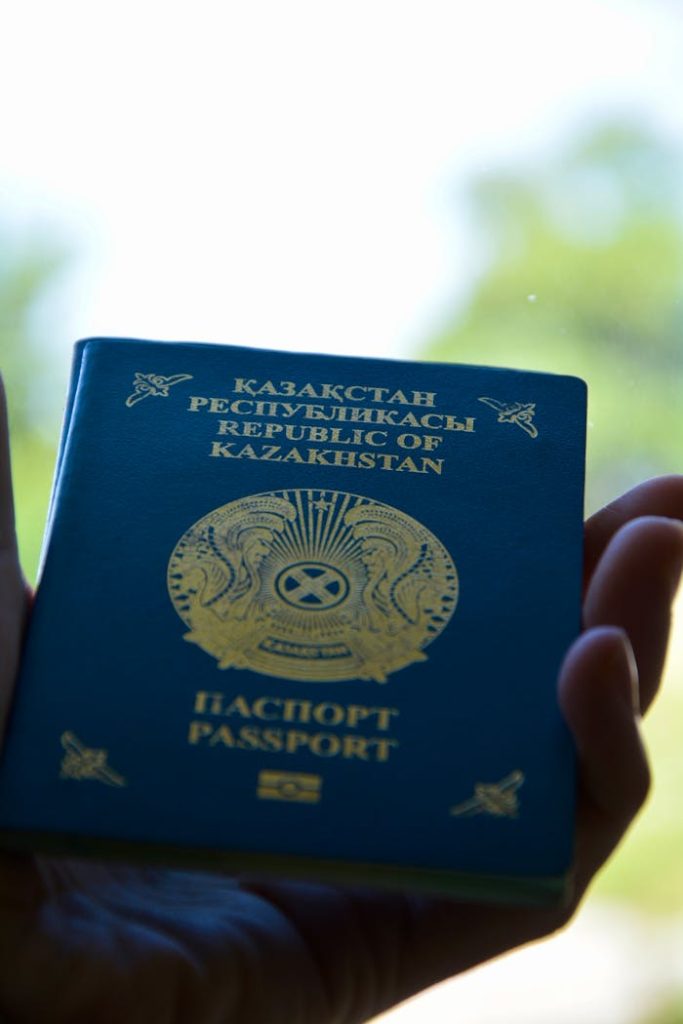 Close-up of a Kazakhstan passport held in hand with a blurred background.